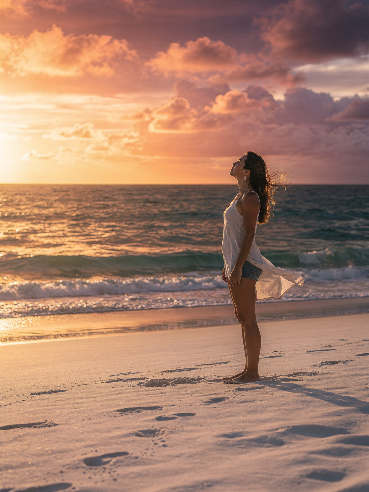 Femme sur une plage au coucher du soleil
